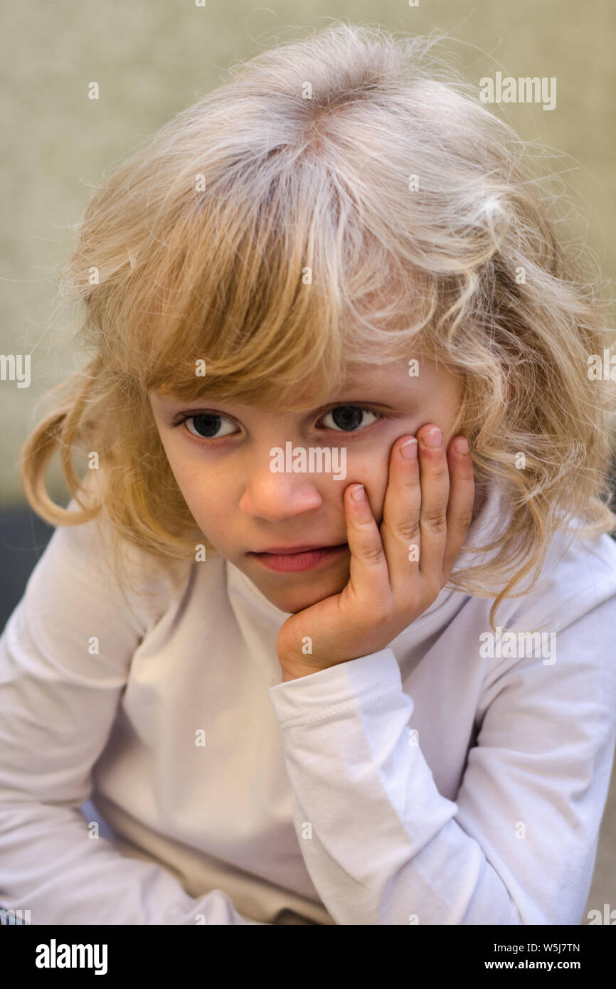 Blonde Mädchen mit blauen Augen denken Stockfoto