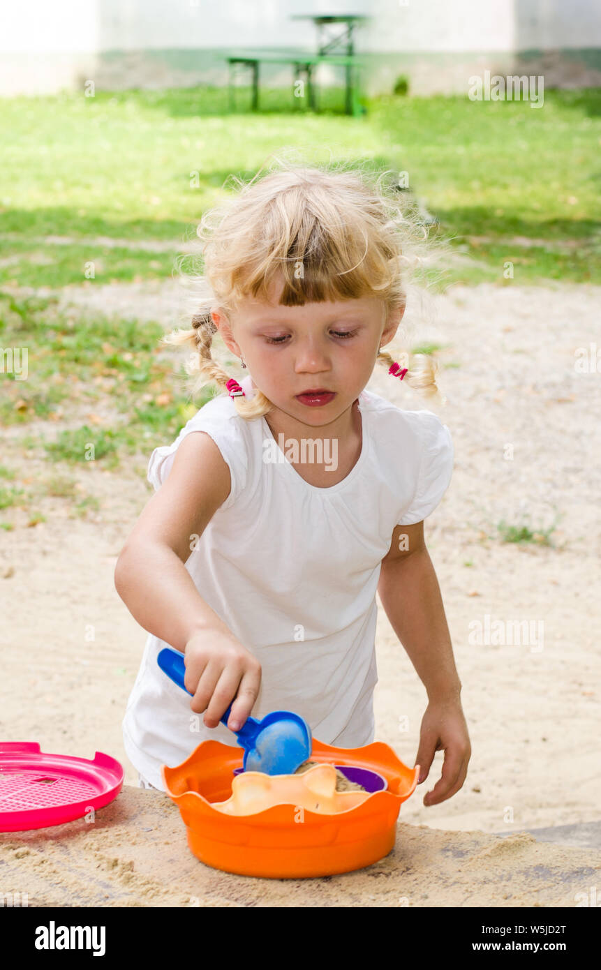 Schöne blonde Mädchen spielen auf dem Spielplatz Stockfoto