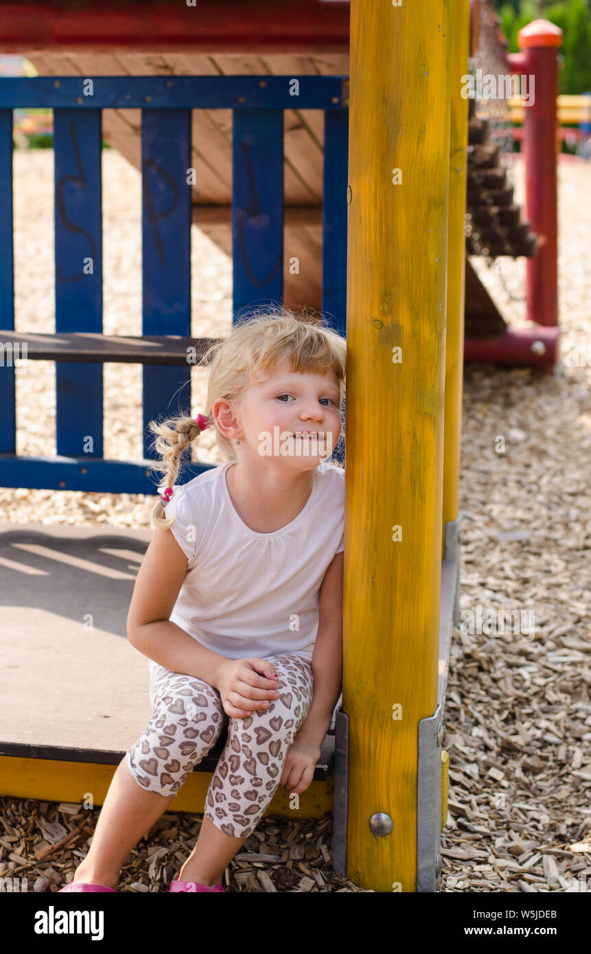 Schöne blonde Mädchen spielen auf dem Spielplatz Stockfoto