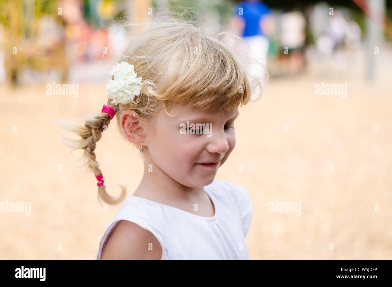 schöne blonde Mädchen mit Blume im Haar Stockfoto