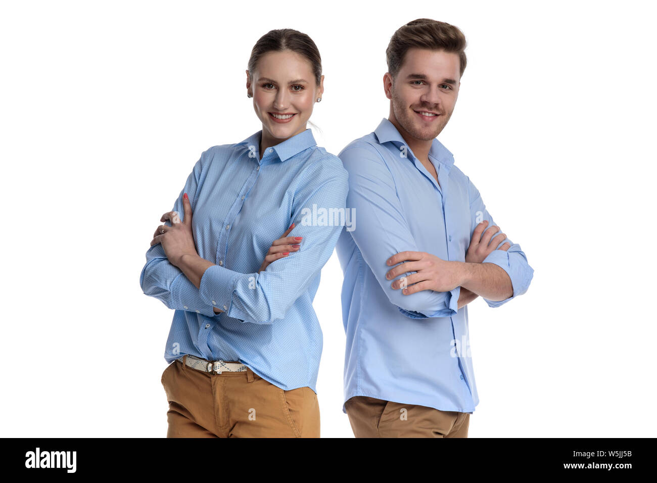 Zuversichtlich junges Paar stehen zusammen mit den Händen auf weißem Hintergrund gekreuzt Stockfoto