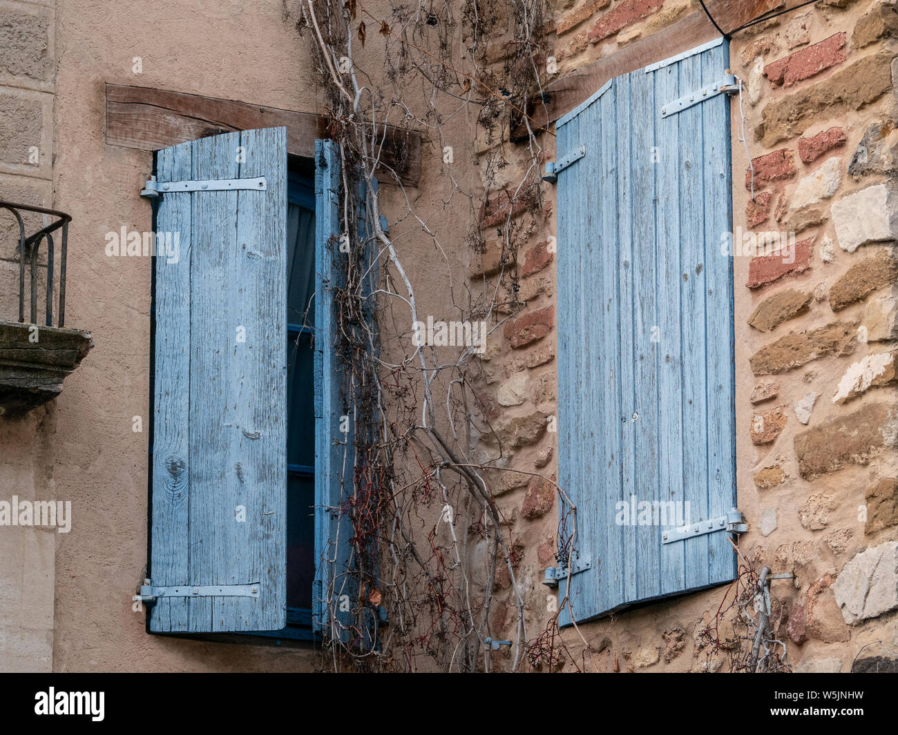 Zwei Holz- Fenster, in blau lackiert, einer geschlossen und der andere halb geschlossen, in einem typischen Haus von Gigondas, Frankreich Stockfoto