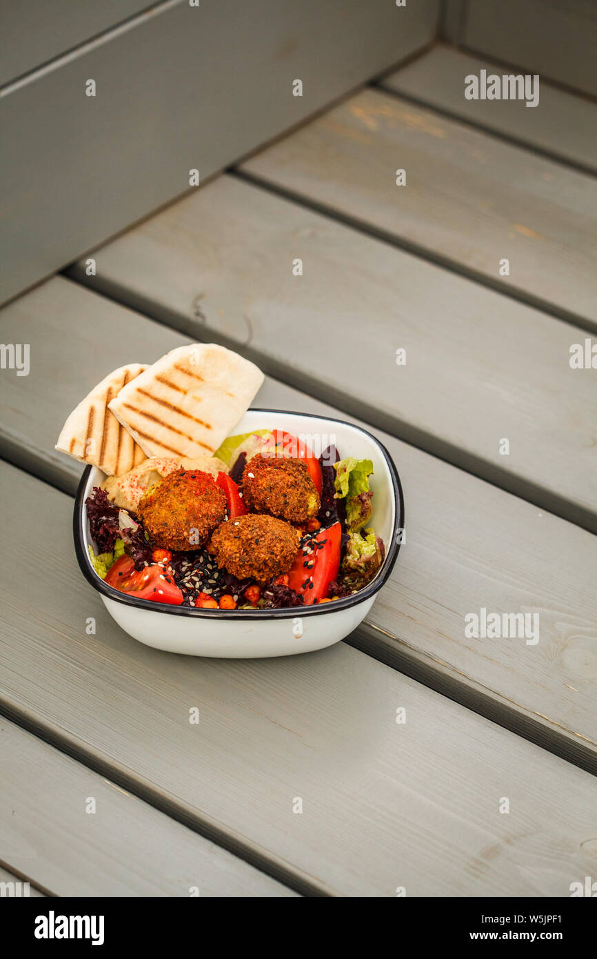 Israelische Street Food. Falafel mit Hummus, Rote-Bete-Salat und Gemüse in einer Schüssel in ein Restaurant. Stockfoto