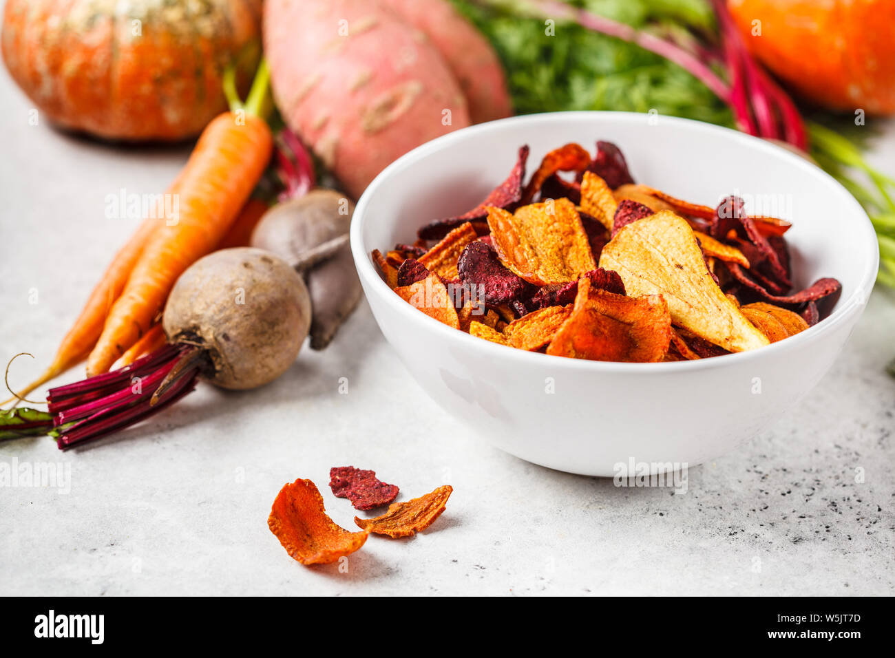 Schüssel gesunde Gemüse Chips aus Rüben, süsse Kartoffeln und Karotten mit Zutaten auf einem weißen Hintergrund. Stockfoto