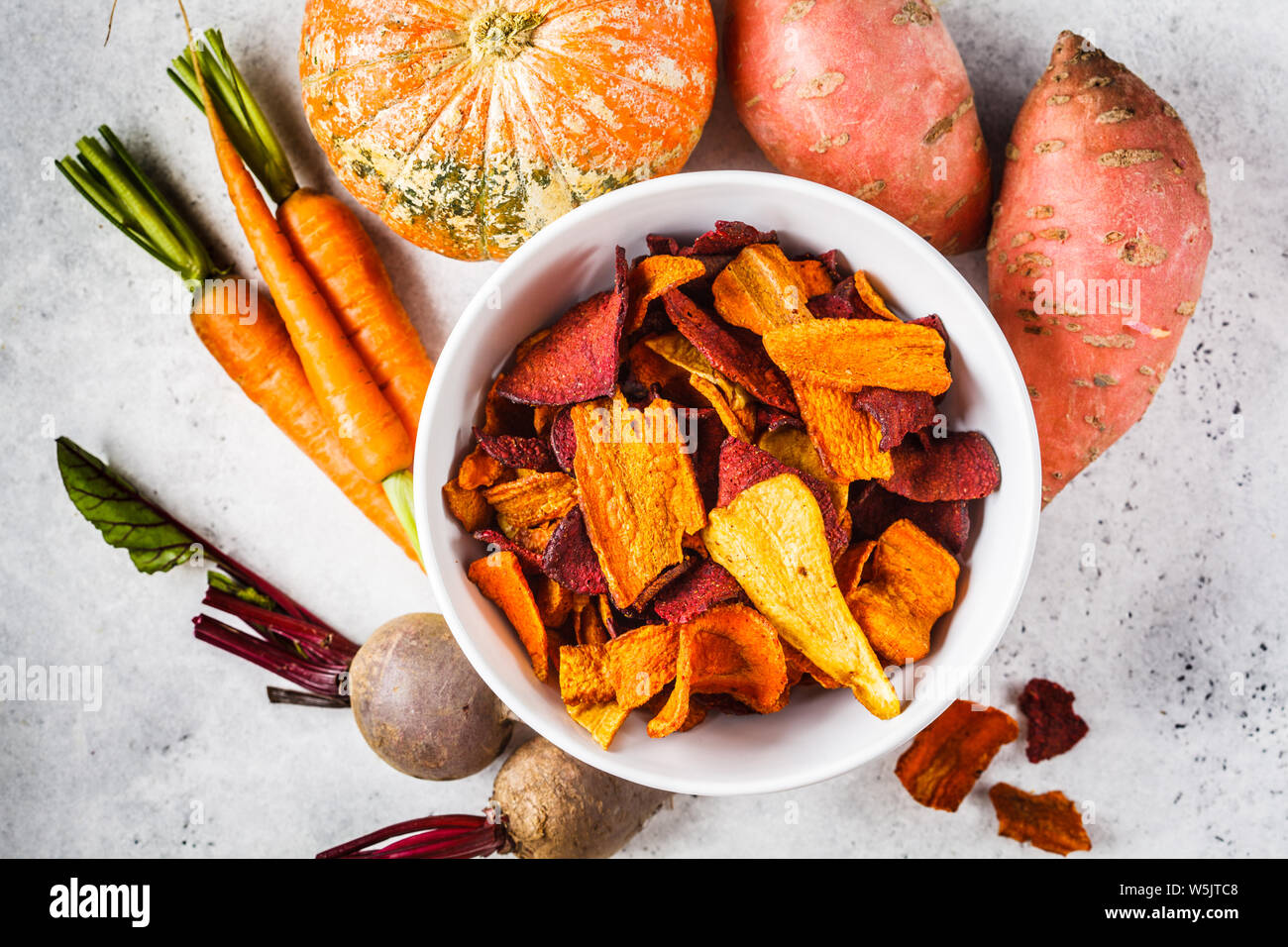 Schüssel gesunde Gemüse Chips aus Rüben, süsse Kartoffeln und Karotten mit Zutaten auf einem weißen Hintergrund. Stockfoto