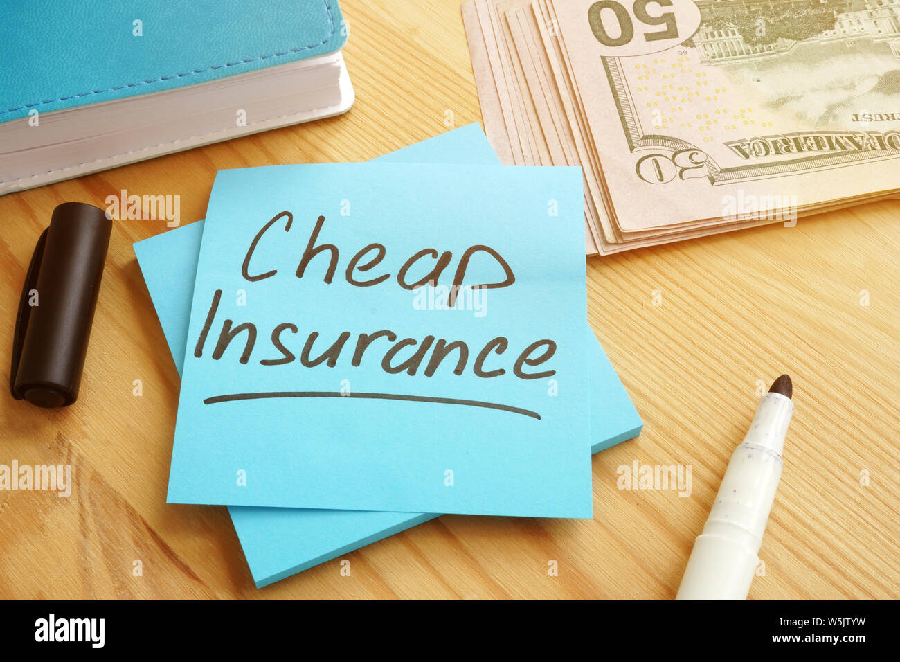 Billig versicherung Konzept. Geld und Notizblock mit Stift. Stockfoto