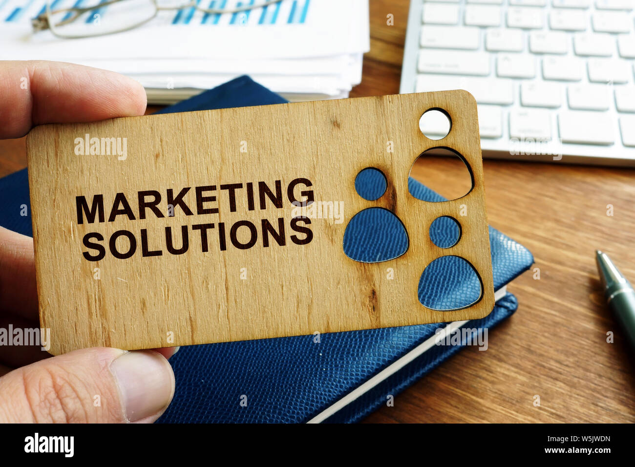 Hand, die Platte mit Marketing Solutions unterzeichnen. Stockfoto