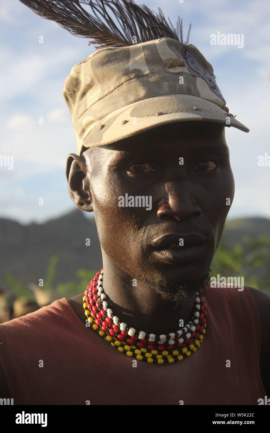 Ein junger Mann, der eine moderne Turkana Cap mit Straußenfedern oben eingefügt Stockfoto