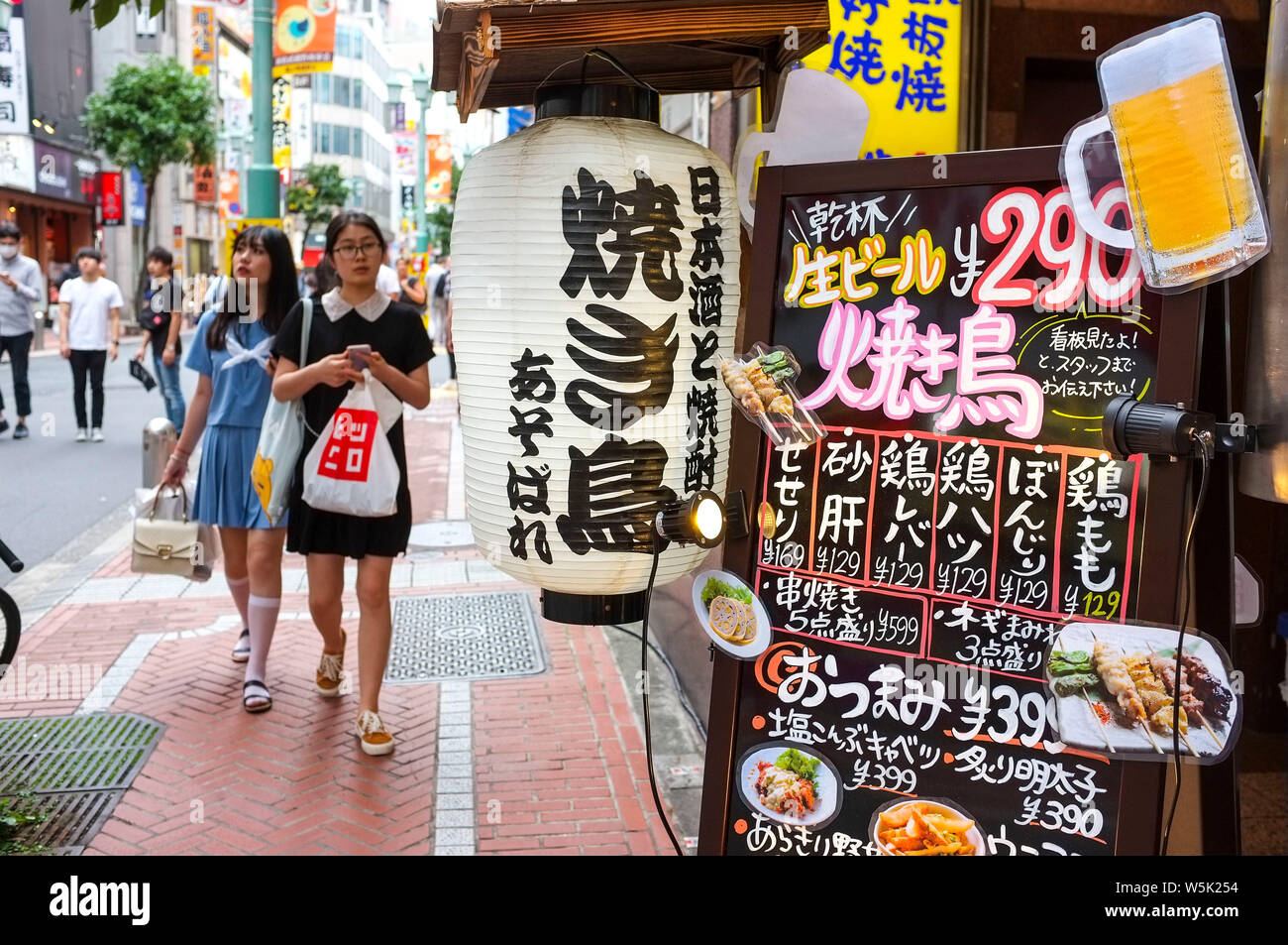 Menschen gehen in der Nähe ein Restaurant Menü in Shinjuku Tokyo. Stockfoto