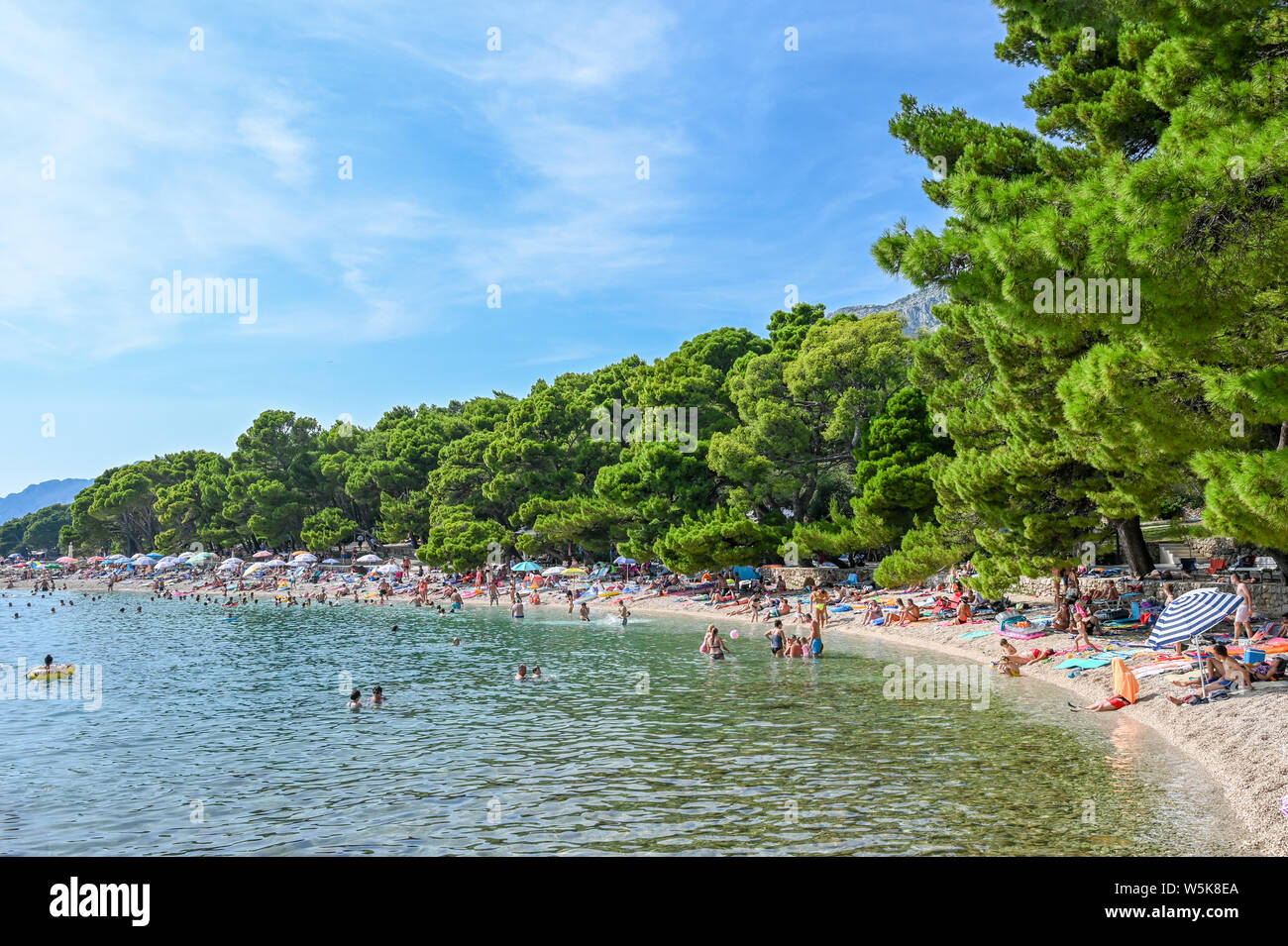 Touristen genießen den Strand von Brela. Die Riviera von Makarska in Kroatien ist bekannt für seine schönen Kiesstränden und kristallklarem Wasser. Stockfoto