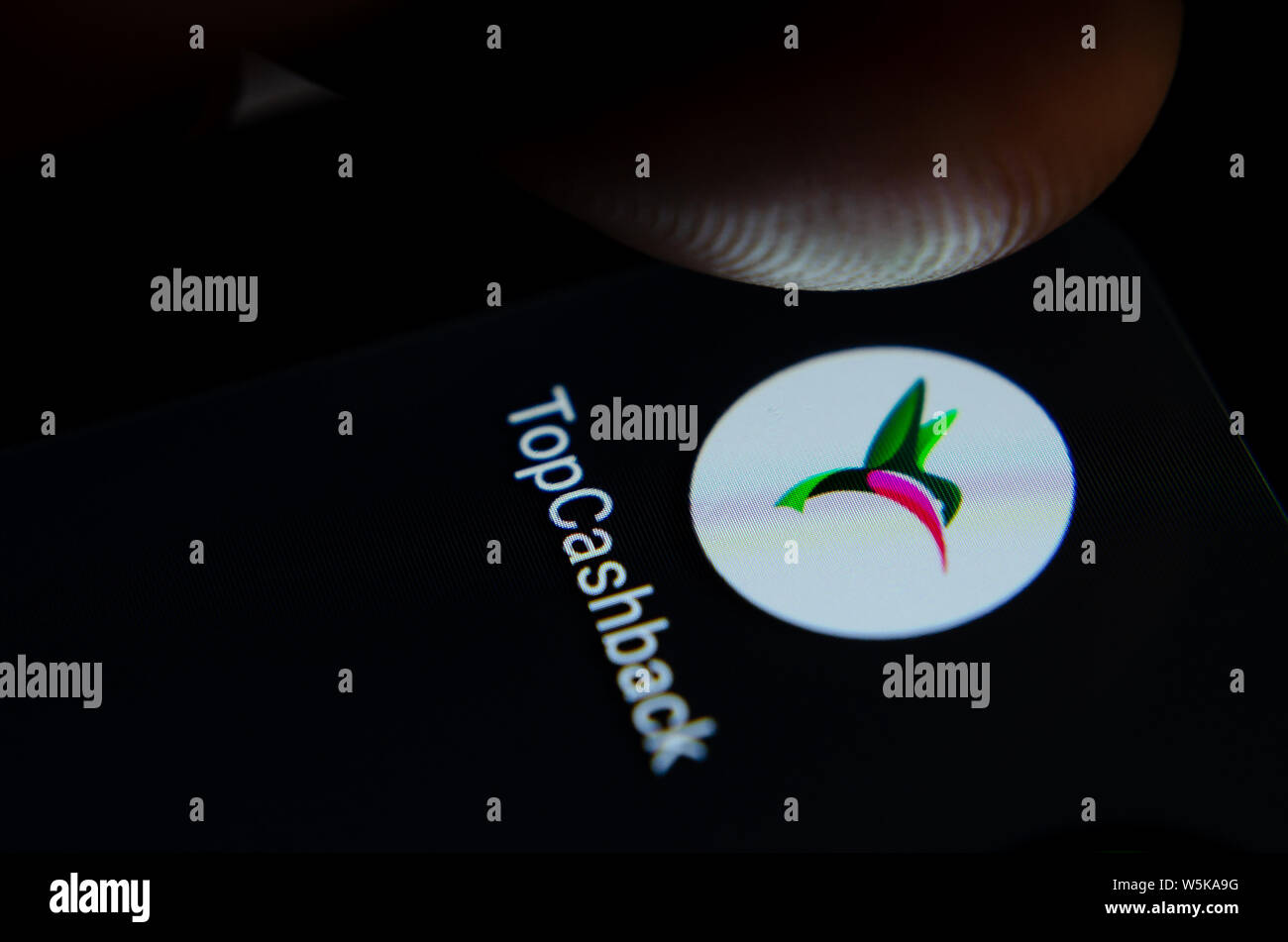 TopCashback App auf dem Bildschirm des Smartphones mit sichtbaren Pixel und die Finger über Sie zu starten. Stockfoto