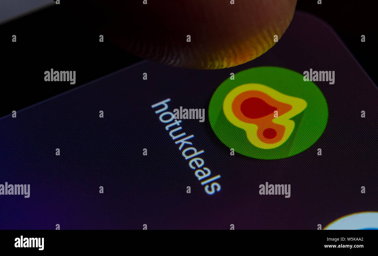 HotUkDeals App auf dem Bildschirm des Smartphones mit sichtbaren Pixel und die Finger über Sie zu starten. Stockfoto