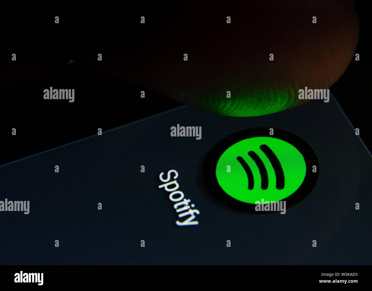 Spotify App auf dem Bildschirm des Smartphones mit sichtbaren Pixel und die Finger über Sie zu starten. Stockfoto