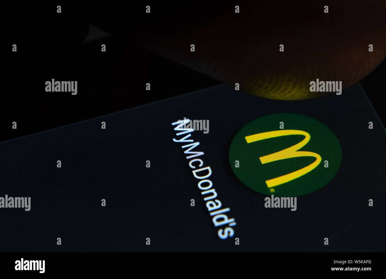 MyMcDonald der App auf dem Bildschirm des Smartphones mit sichtbaren Pixel und die Finger über Sie zu starten. Stockfoto