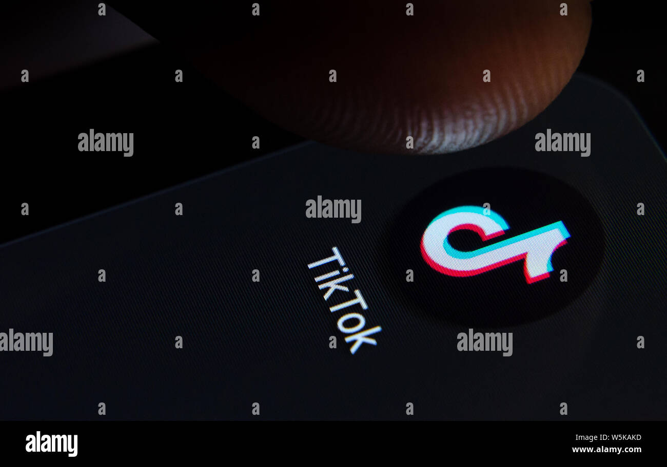 TikTok App auf dem Bildschirm des Smartphones mit sichtbaren Pixel und die Finger über Sie zu starten. Stockfoto