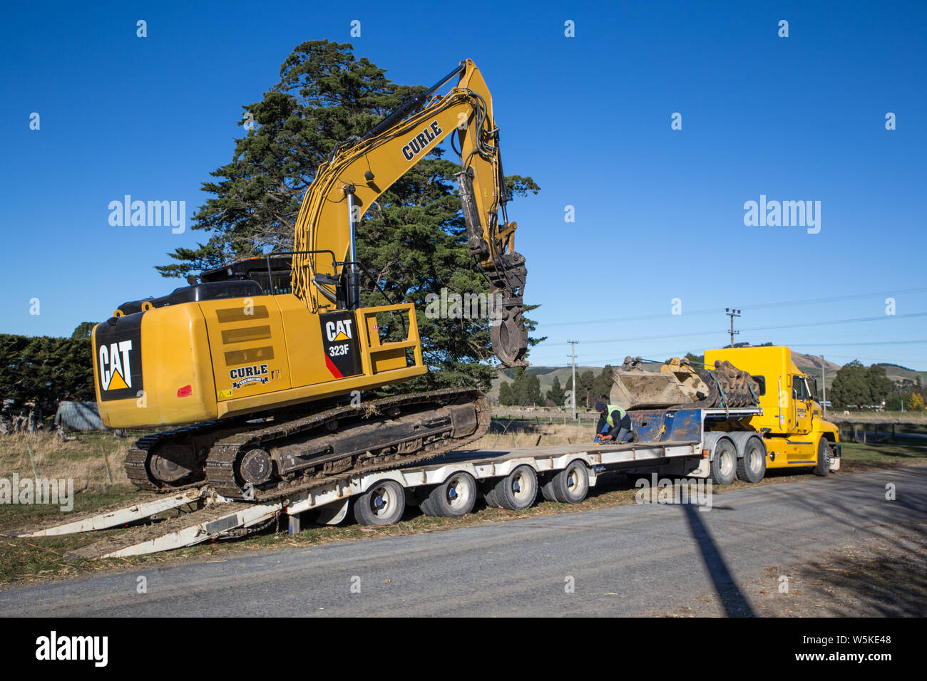 Sheffield, Canterbury, Neuseeland, 10. Juli 2019: Ein Bagger ist von einem großen Lkw auf einer Baustelle in einem ländlichen Gebiet transportiert Stockfoto