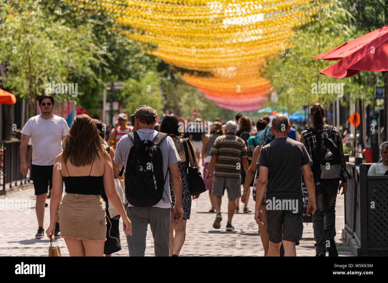 Montreal, CA - 27. Juli 2019: Menschen zu Fuß unter dem Regenbogen Bälle kunst Installation '18 Schattierungen von Gay' auf saint-catherine Straße im Gay Village Stockfoto