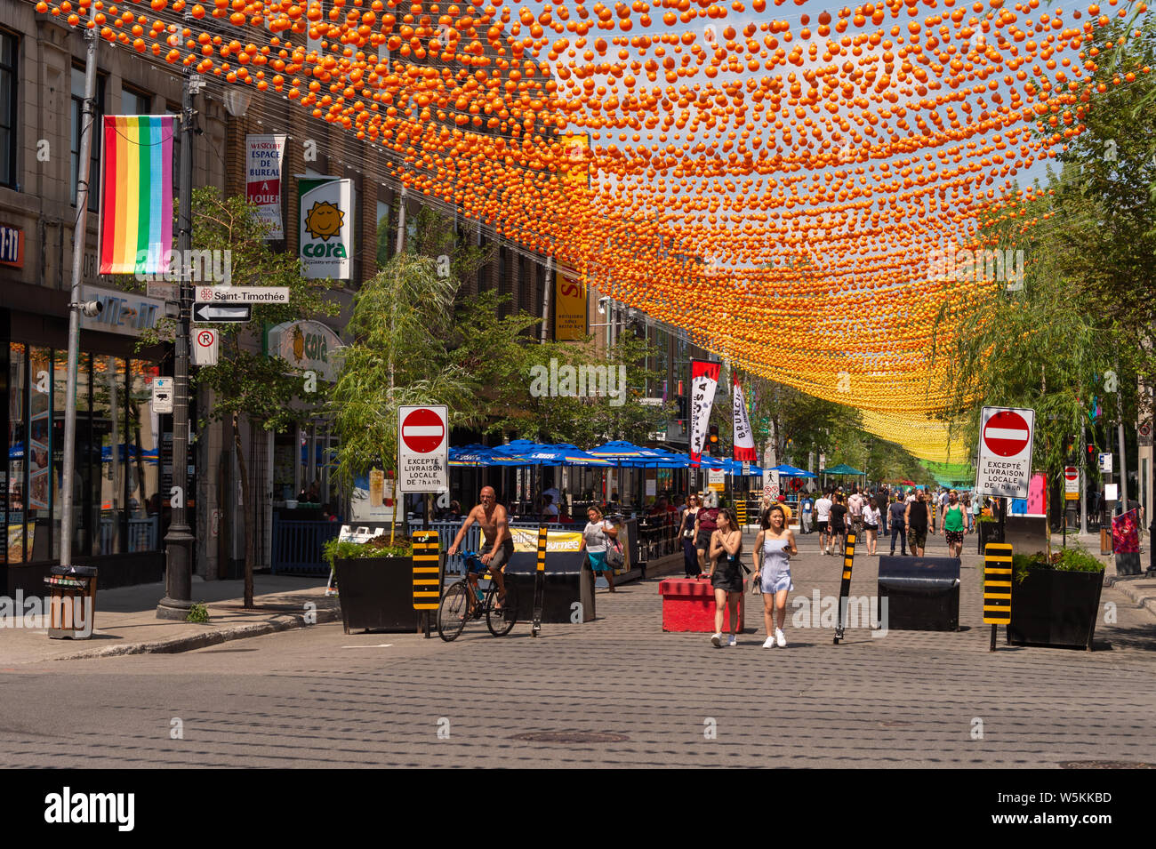 Montreal, CA - 27. Juli 2019: Menschen zu Fuß unter dem Regenbogen Bälle kunst Installation '18 Schattierungen von Gay' auf saint-catherine Straße im Gay Village Stockfoto