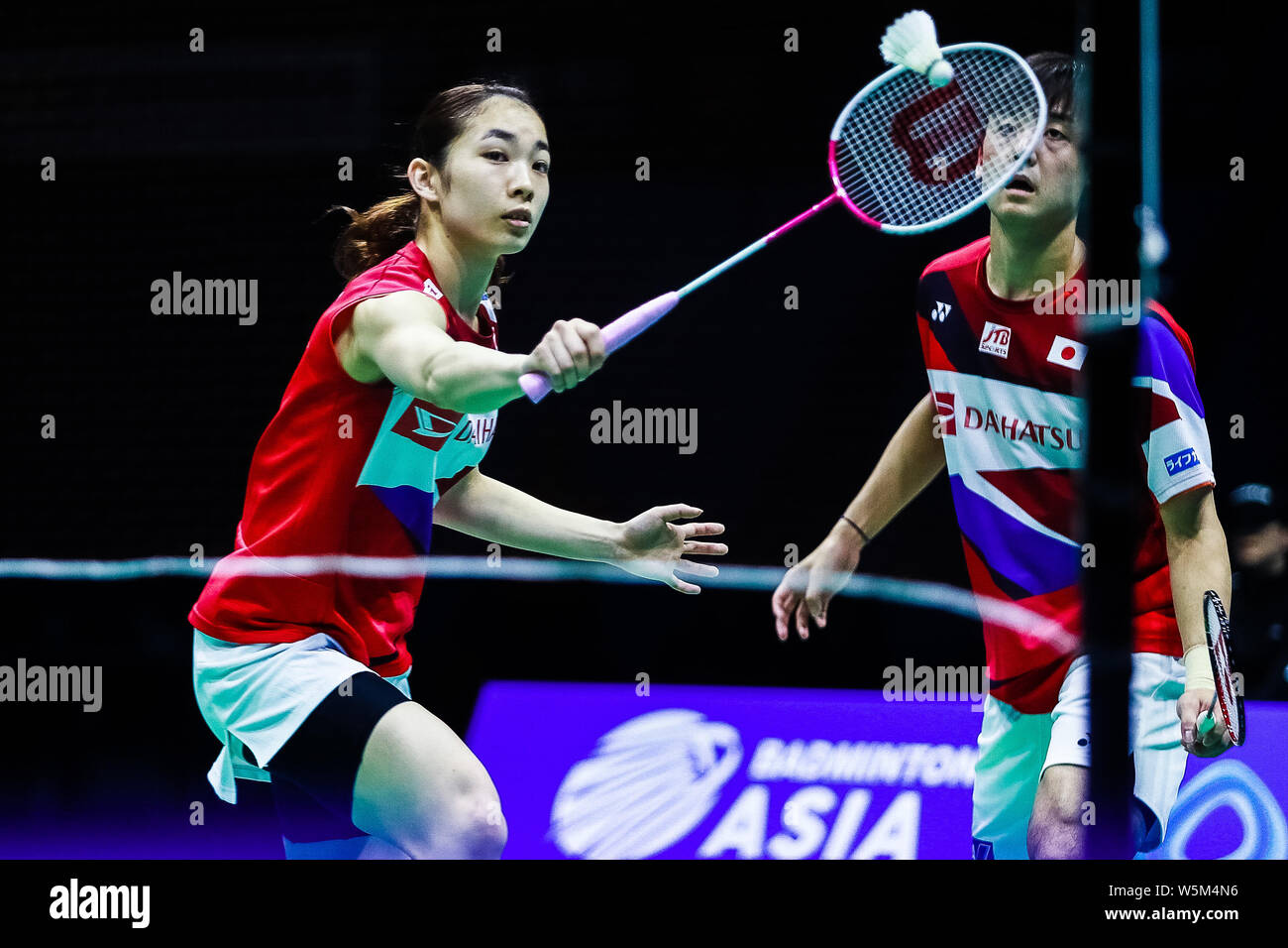 Misaki Matsutomo von Japan gibt einen Schuß zu Tang Chun Mann und Tse-Ying Suet von Hong Kong in der ersten Runde des gemischten Doppel während der 2019 B Stockfoto