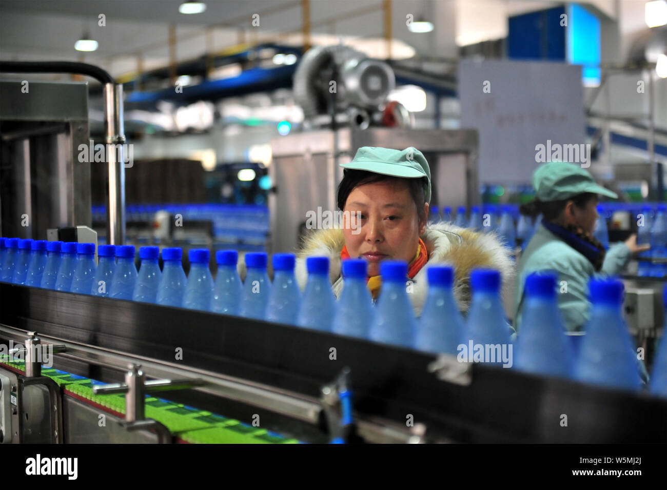 ---- Ein chinesischer Arbeiter prüft Wahaha gereinigtes Wasser in Flaschen auf dem Fließband in einer Fabrik in Yichang, Provinz Hubei, China 11. Stockfoto