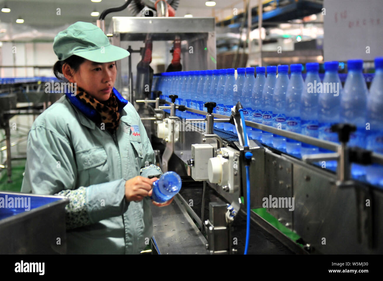 ---- Ein chinesischer Arbeiter prüft Wahaha gereinigtes Wasser in Flaschen auf dem Fließband in einer Fabrik in Yichang, Provinz Hubei, China 11. Stockfoto