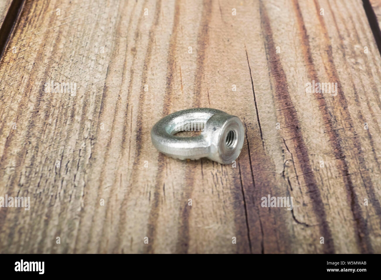 Ringmutter verzinkt auf Holz- Hintergrund. Stockfoto