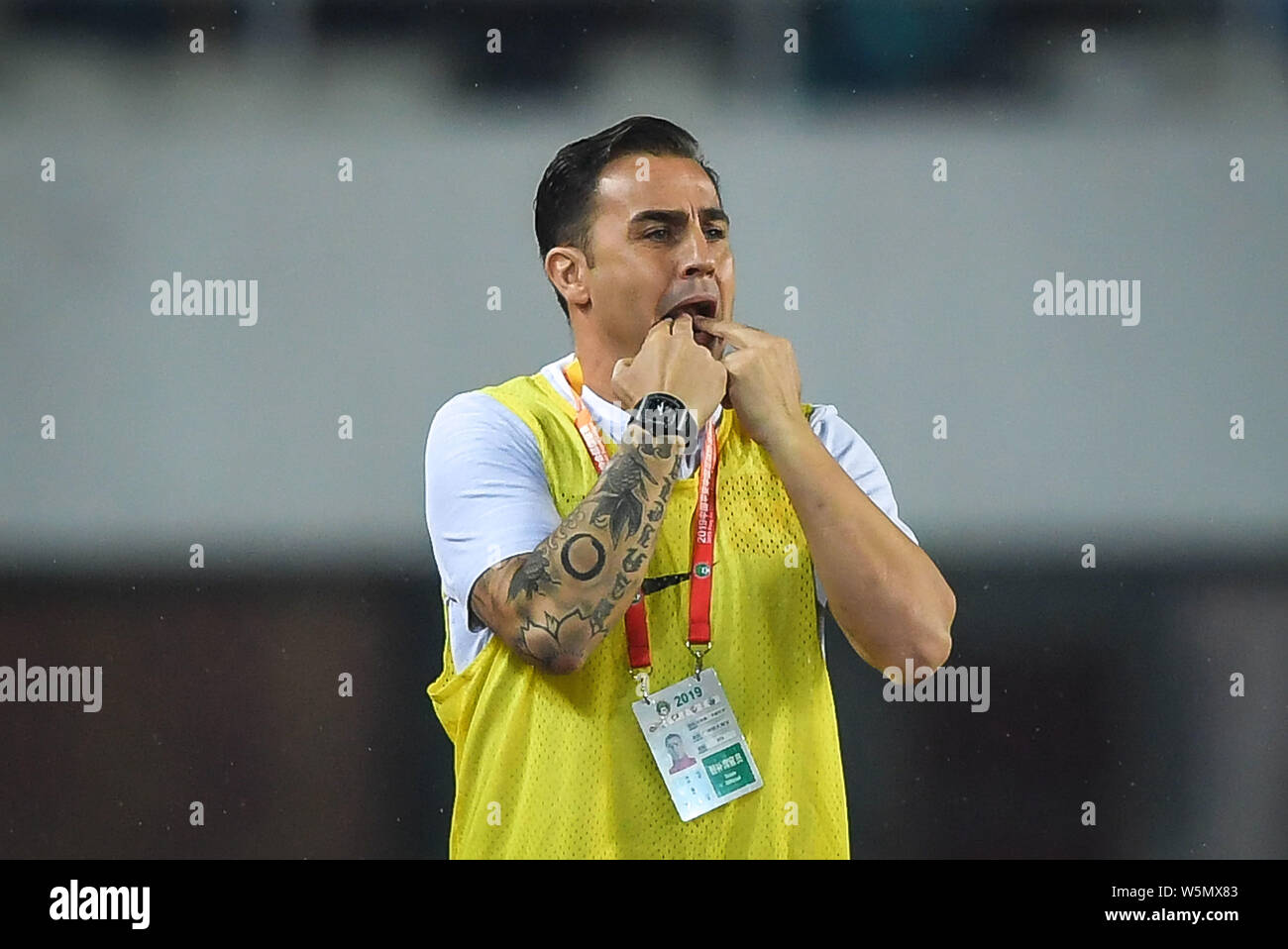 Head Coach Fabio Cannavaro von Guangzhou Evergrande Pfeifen zu geben Anweisungen an seine Spieler gegen Shandong Luneng während ihrer 6. ro zu konkurrieren Stockfoto