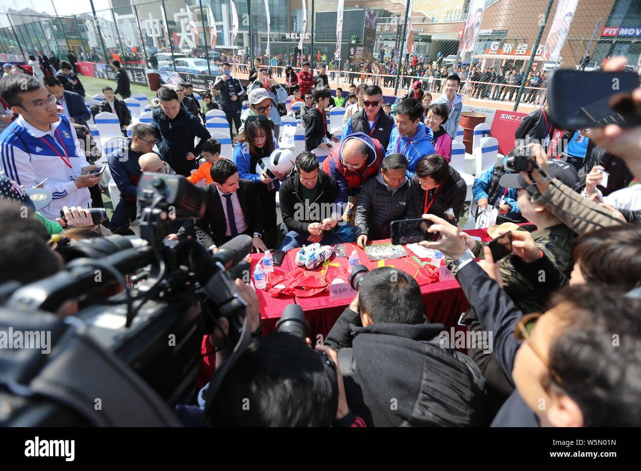 Pensionierter portugiesischer Fußballspieler Luis Figo, Mitte, Autogramme für die Fans während der Eröffnungsfeier für siic Cup 2019 Qingdao Kinder- gr&ou Stockfoto