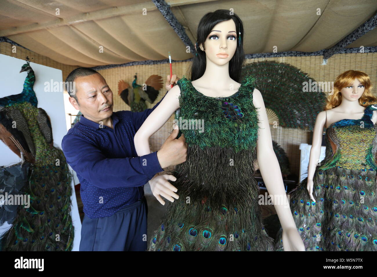 Chinesische hofbesitzers Xia Linrong zeigt ein Brautkleid aus Pfauenfedern in De' eine Grafschaft, Conghua City, der ostchinesischen Provinz Jiangxi, 16 Stockfoto