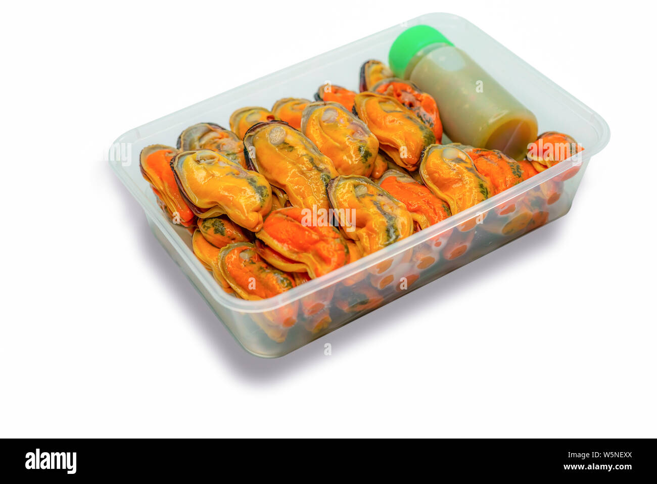 Gedämpfte Muscheln und köstlichen Flasche spicy Seafood Soße in Kunststoffbox für die Lieferung. Muschel Fleisch gekocht ohne Schale in Kunststoffbox isoliert Stockfoto