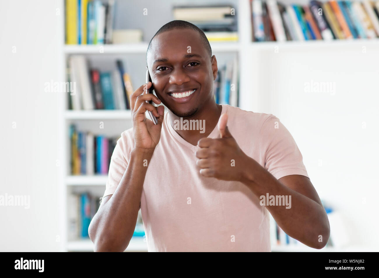 African American kahl unter der Leitung reifer Mann am Telefon zuhause zu Hause lacht Stockfoto