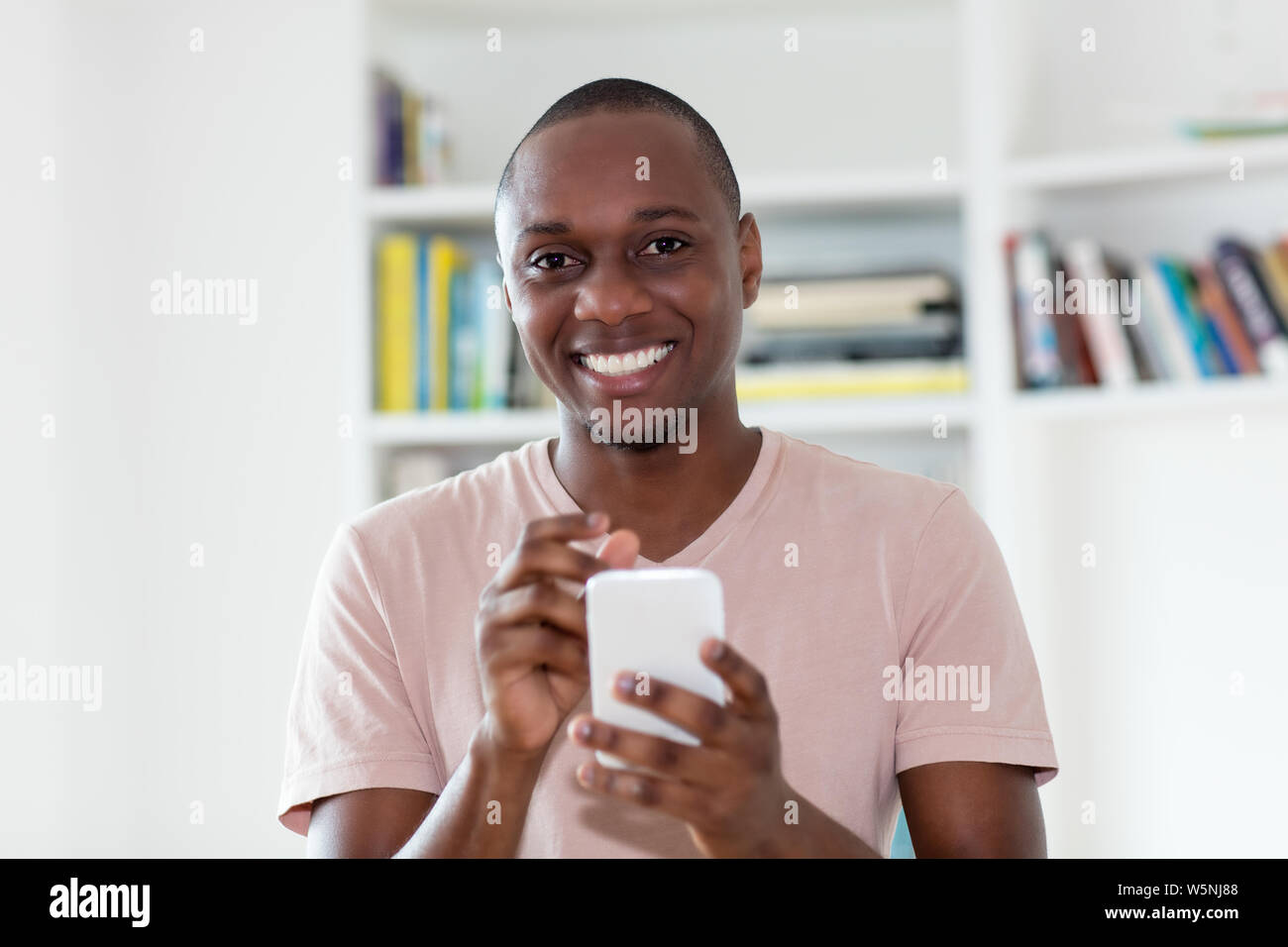 African American kahl unter der Leitung reifer Mann sms drinnen zu Hause Stockfoto
