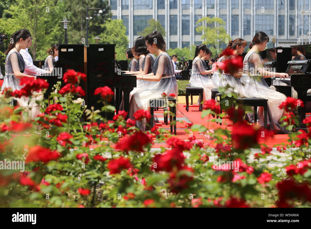 Die Teilnehmer spielen Klavier bilden die Form der 70 70. Jahrestag der Gründung der Volksrepublik China während einen Wettbewerb, der sich an die Mitteilung Unive zu feiern. Stockfoto