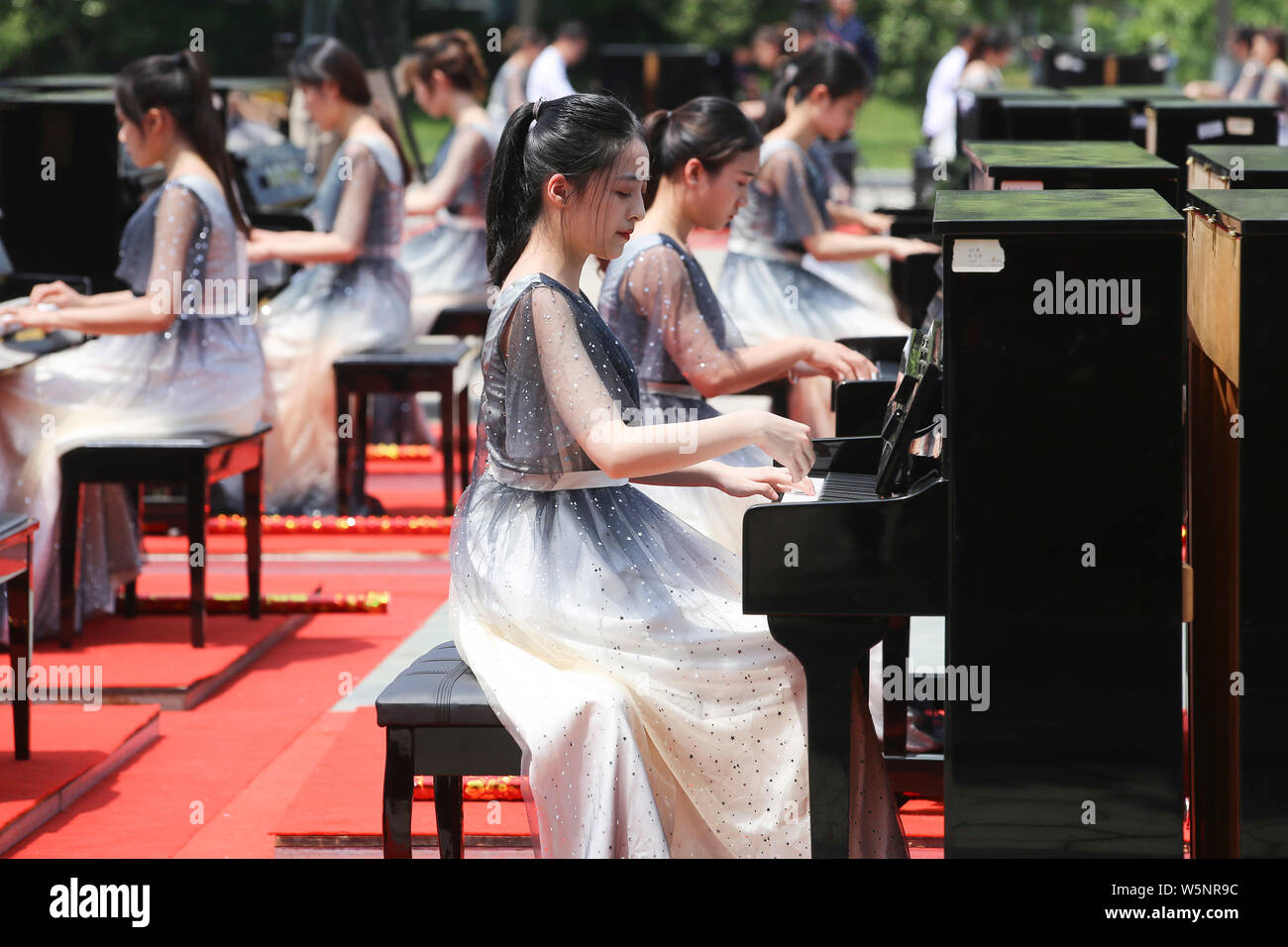 Die Teilnehmer spielen Klavier bilden die Form der 70 70. Jahrestag der Gründung der Volksrepublik China während einen Wettbewerb, der sich an die Mitteilung Unive zu feiern. Stockfoto