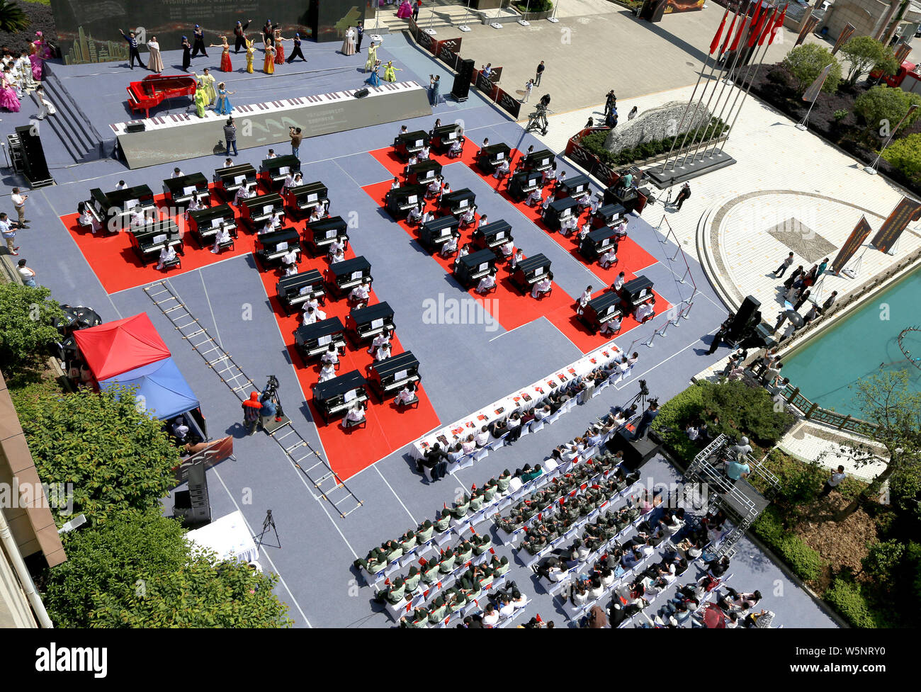 Die Teilnehmer spielen Klavier bilden die Form der 70 70. Jahrestag der Gründung der Volksrepublik China während einen Wettbewerb, der sich an die Mitteilung Unive zu feiern. Stockfoto