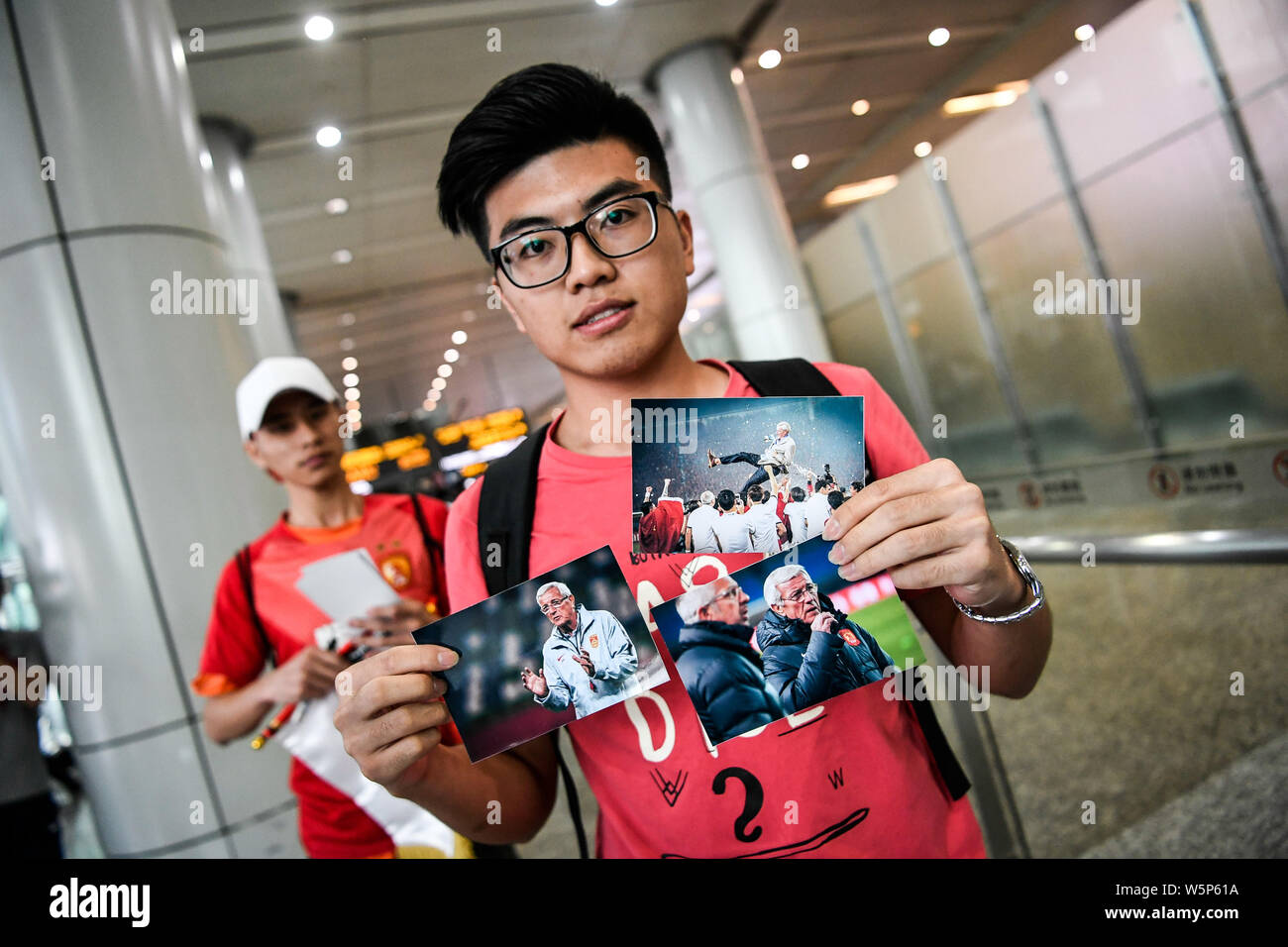 Chinesische Fans halten Banner Unterstützung von Marcello Lippi Zurück zur zweiten Stint als Cheftrainer der chinesischen Nationalmannschaft bei der guangzho zu zeigen Stockfoto