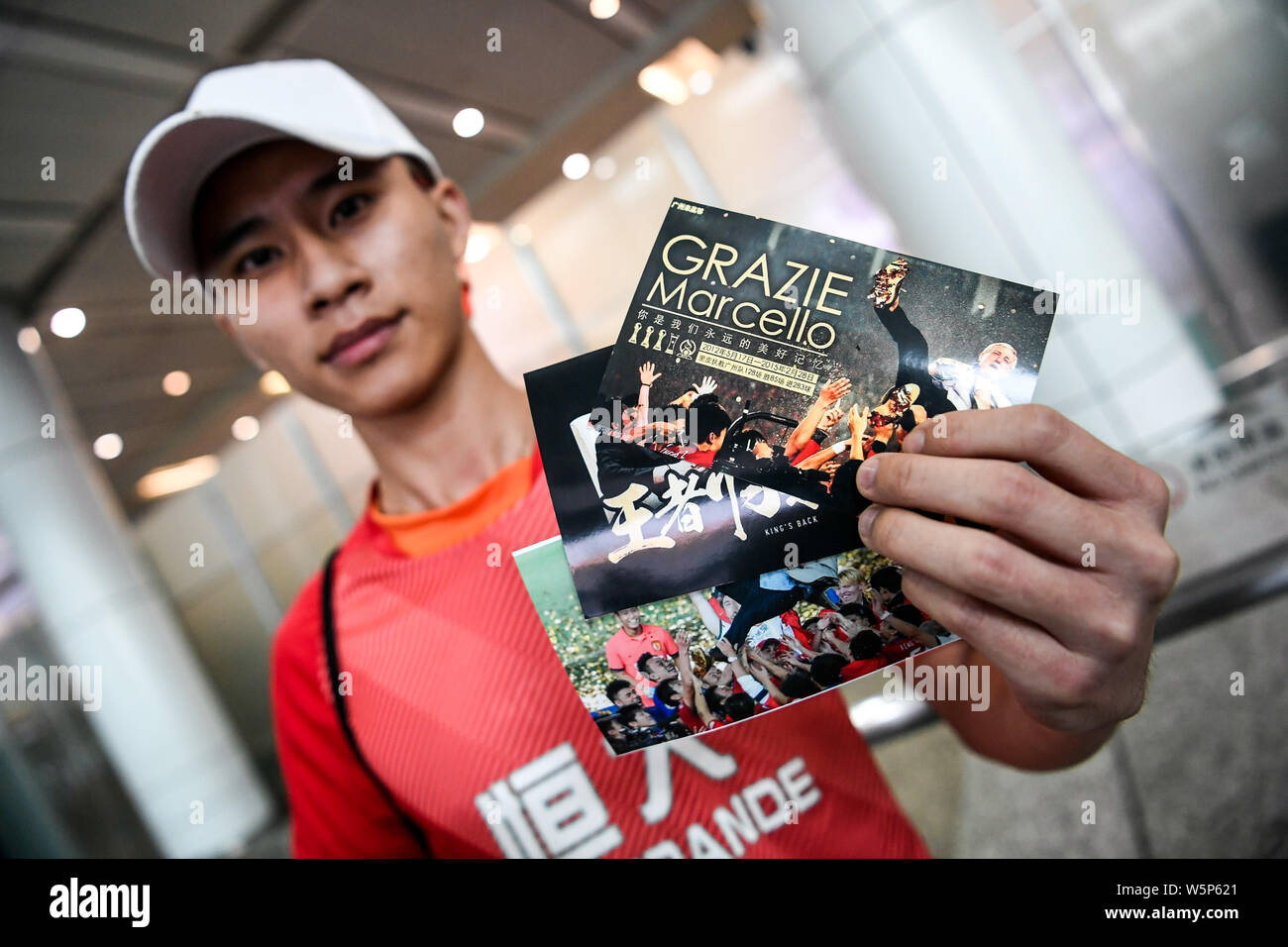Chinesische Fans halten Banner Unterstützung von Marcello Lippi Zurück zur zweiten Stint als Cheftrainer der chinesischen Nationalmannschaft bei der guangzho zu zeigen Stockfoto