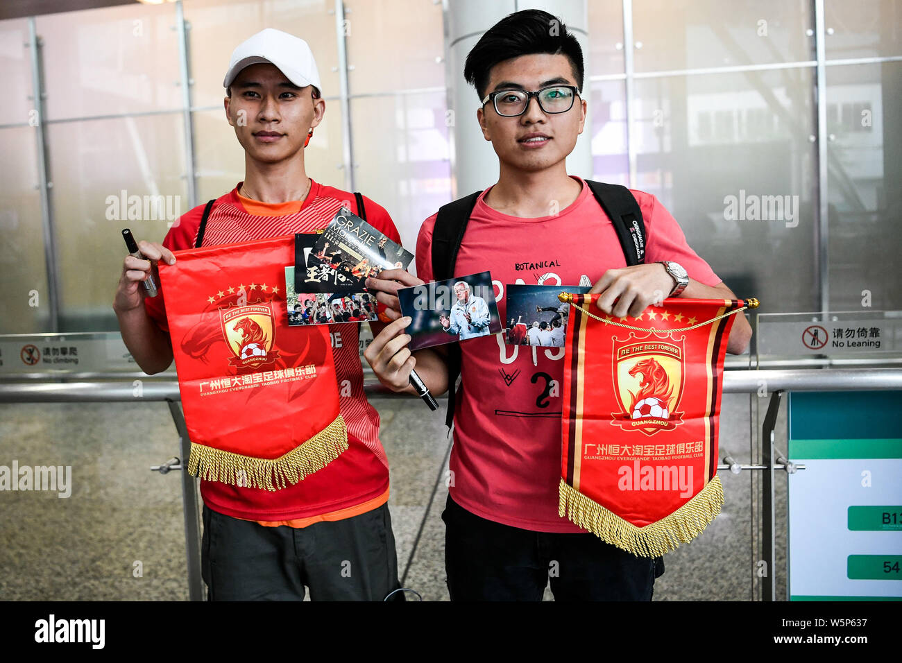 Chinesische Fans halten Banner Unterstützung von Marcello Lippi Zurück zur zweiten Stint als Cheftrainer der chinesischen Nationalmannschaft bei der guangzho zu zeigen Stockfoto