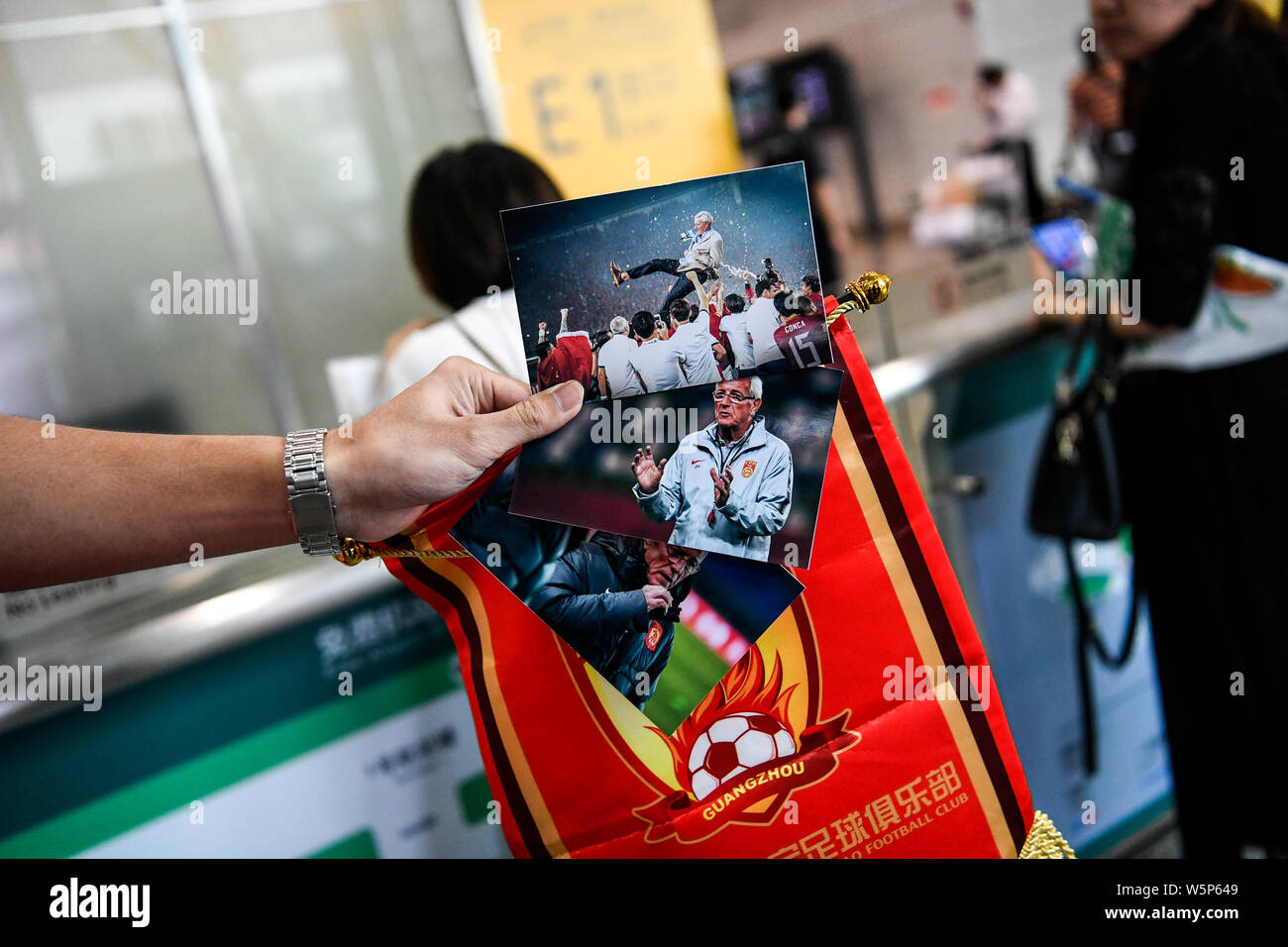 Chinesische Fans halten Banner Unterstützung von Marcello Lippi Zurück zur zweiten Stint als Cheftrainer der chinesischen Nationalmannschaft bei der guangzho zu zeigen Stockfoto