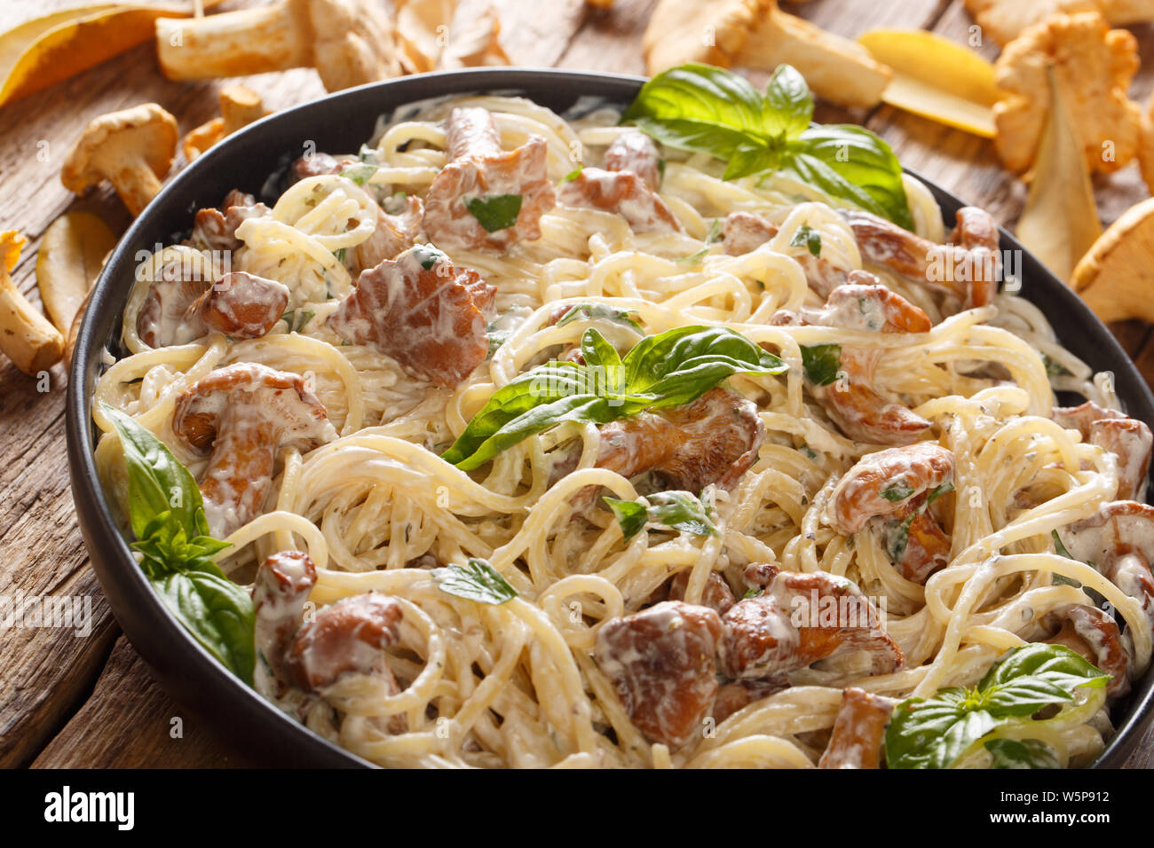 Köstliche Spaghetti mit gebratenen Pfifferlingen in einer cremigen Käse sauce Close-up auf einem Teller auf den Tisch. Horizontale Stockfoto