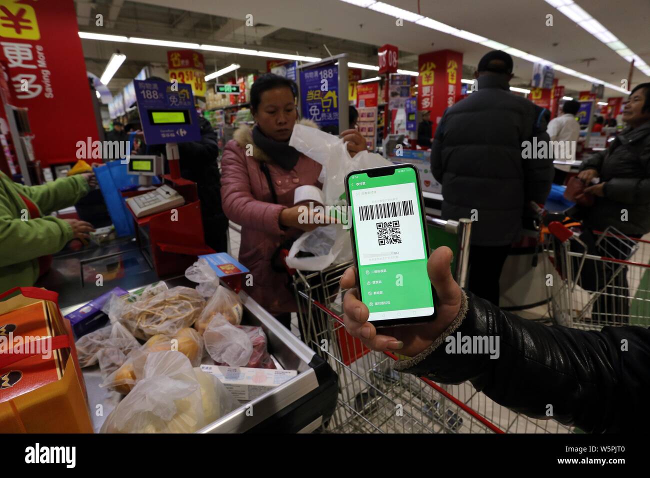 ---- Ein anwohner verwendet sein Smartphone den QR-Code gescannt haben durch die mobile App von Tencent WeChat Funktion Zahlung seiner günstig online zu bezahlen Stockfoto