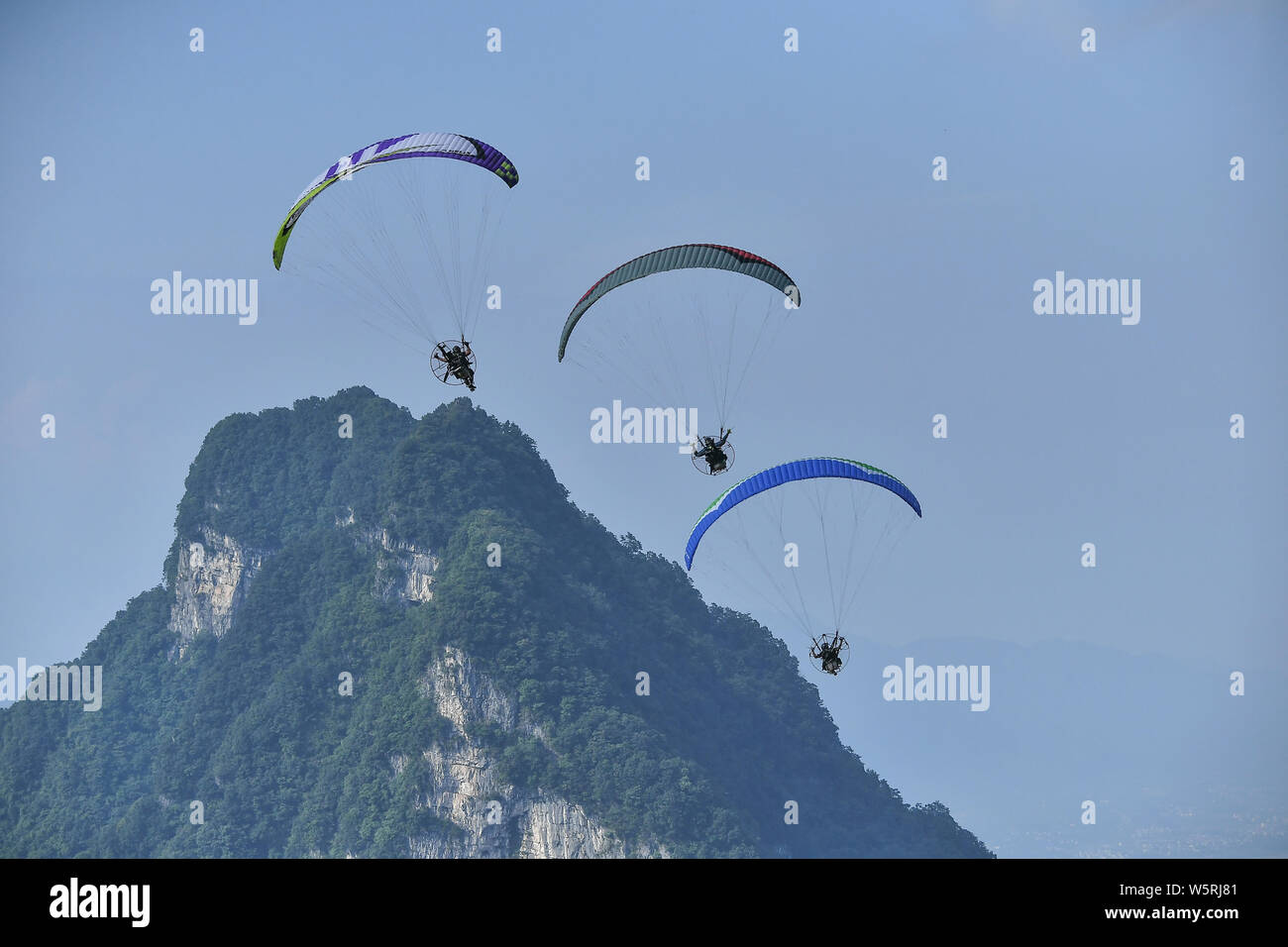 Ein wingsuit Flyer springt von einem hohen Ort, um durch die Luft gleiten während einer Wingsuit Fliegen Wettbewerb auf tianmen Mountain Scenic Spot in Zha gehalten Stockfoto