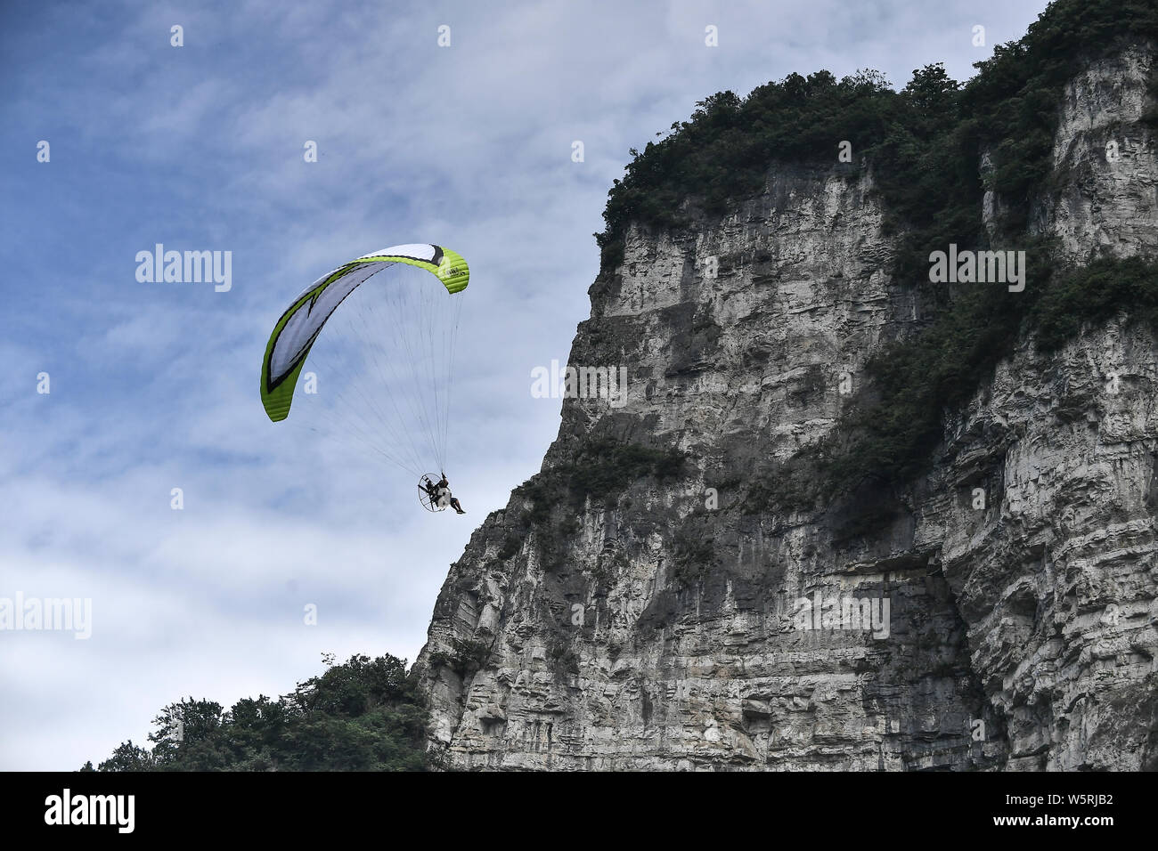 Ein wingsuit Flyer springt von einem hohen Ort, um durch die Luft gleiten während einer Wingsuit Fliegen Wettbewerb auf tianmen Mountain Scenic Spot in Zha gehalten Stockfoto