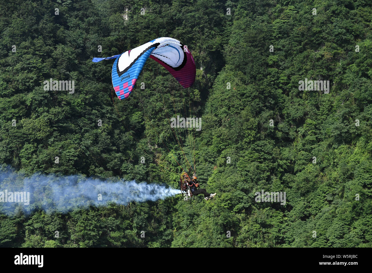 Ein wingsuit Flyer springt von einem hohen Ort, um durch die Luft gleiten während einer Wingsuit Fliegen Wettbewerb auf tianmen Mountain Scenic Spot in Zha gehalten Stockfoto