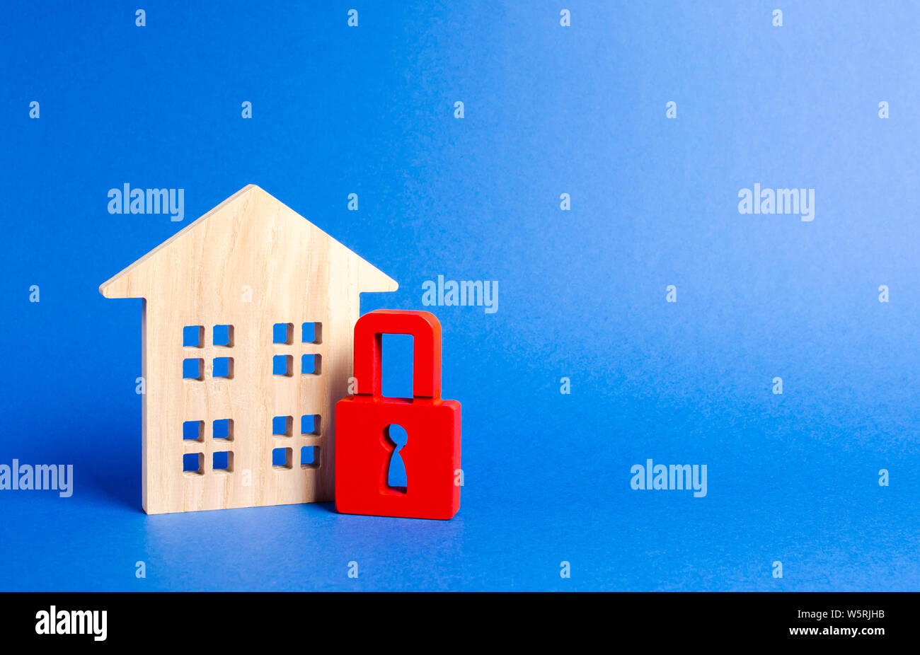 Holzhaus und ein rotes Vorhängeschloss. Schutz und Sicherheit. Nicht verfügbar und teure Immobilien. Haus Versicherung Einziehung für Schulden. alarm System. Seiz Stockfoto