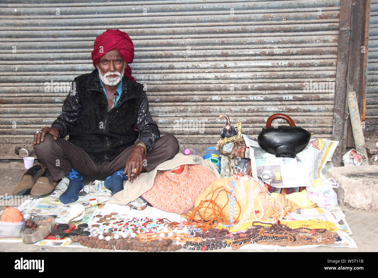 Älterer Mann, der Perlenketten auf einem Straßenmarkt verkauft Stockfoto