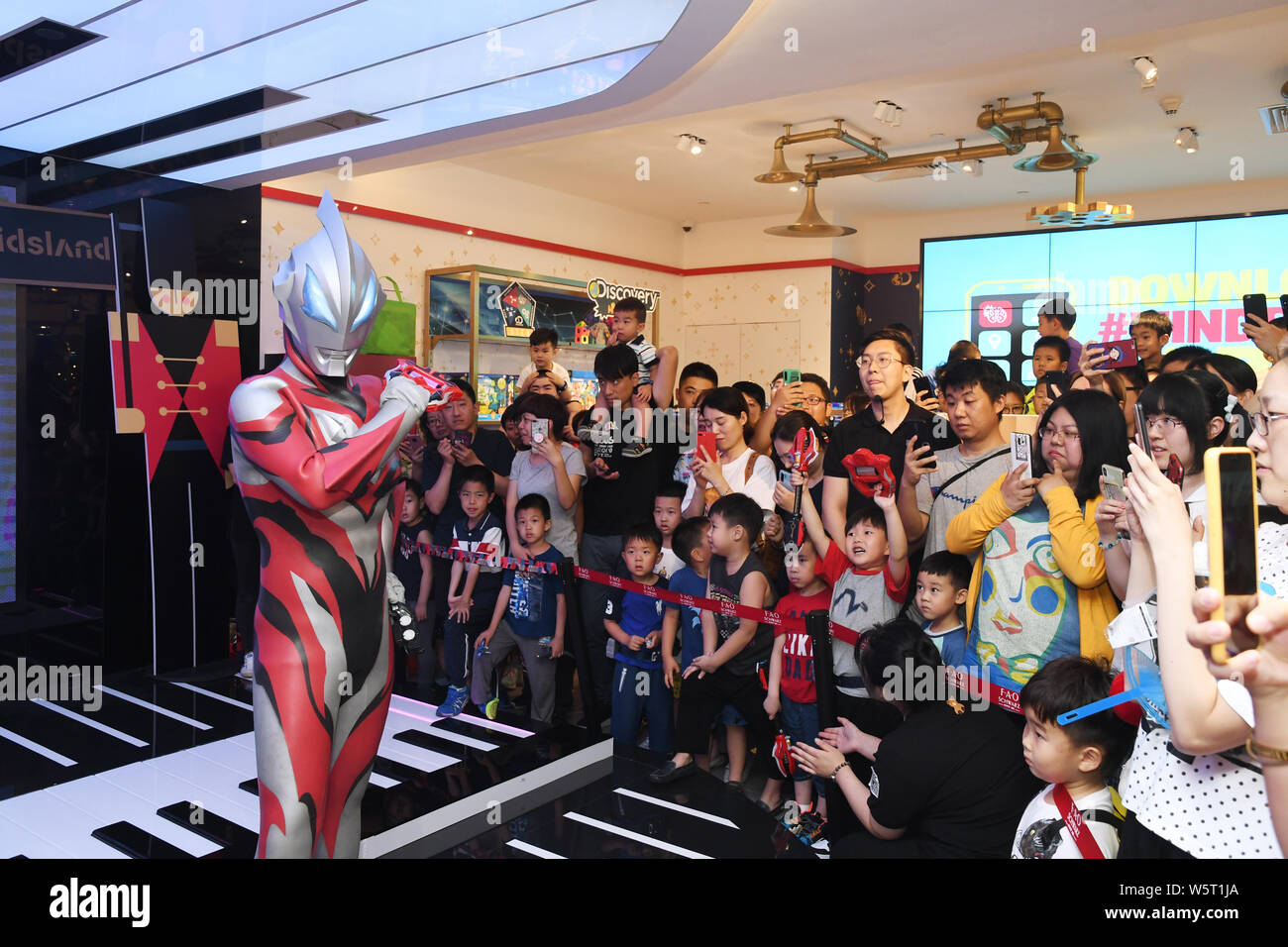 Ein chinesischer Arbeiter kleidet sich wie Ultraman Geed tokusatsu aus dem Japanischen TV-Serie der Internationalen Kinder Tag für Tag Shopping mals zu feiern. Stockfoto