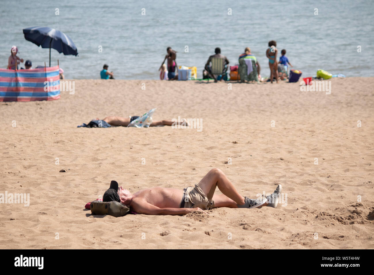Warmes Wetter in Skegness. Mann auf eigene Sonnenbaden am Strand. Stockfoto