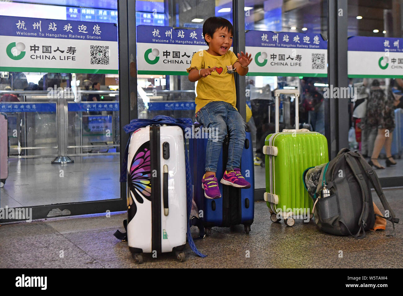 ---- Links - hinter Kind aufgeregt als er sich darauf vorbereitet, wieder zu Hause am Bahnhof Hangzhou in Hangzhou city zu kommen, der East China Zhejiang pro Stockfoto