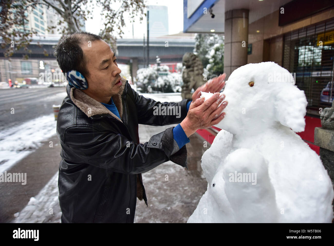 Chinesische bank Security Guard zunamen Du macht einen Schnee Skulptur mit der Form von Zhu Bajie, ein Charakter aus der Chinesischen klassischen Reise in die W Stockfoto